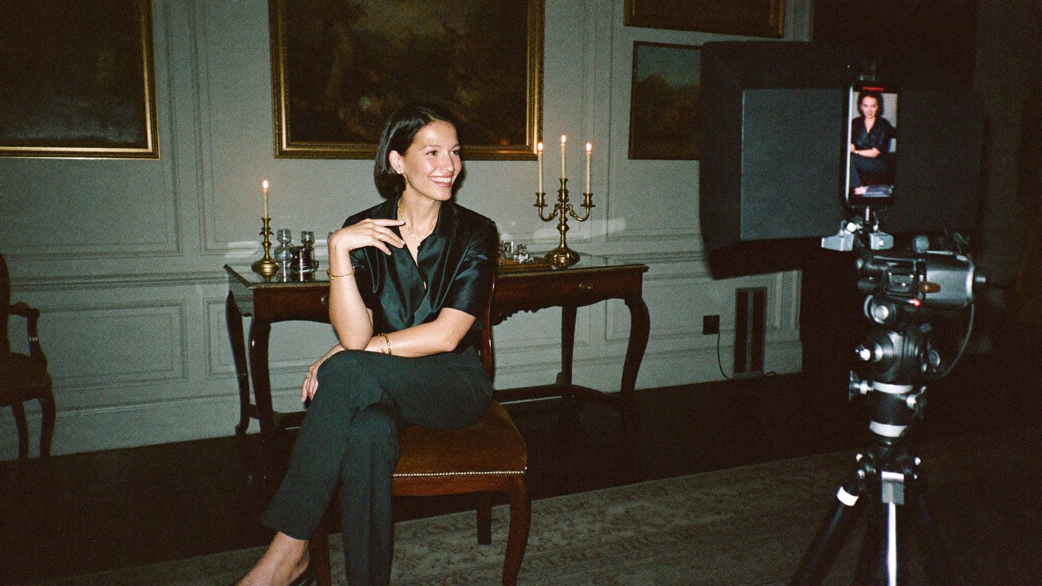 An advisor mid-story while being filmed in a candlelit drawing room
